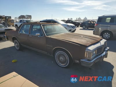 Czwarte zdjęcie samochodu z boku: 1984 OLDSMOBILE DELTA 88 ROYALE BROUGHAM VIN:1G3AY69YXE9725875 - miniatura