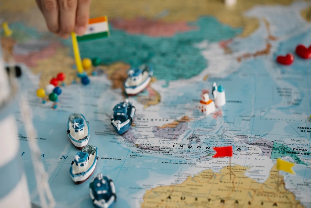 Mapa świata i statuetka samochodu, symbolizujące mienie przesiedleńcze.