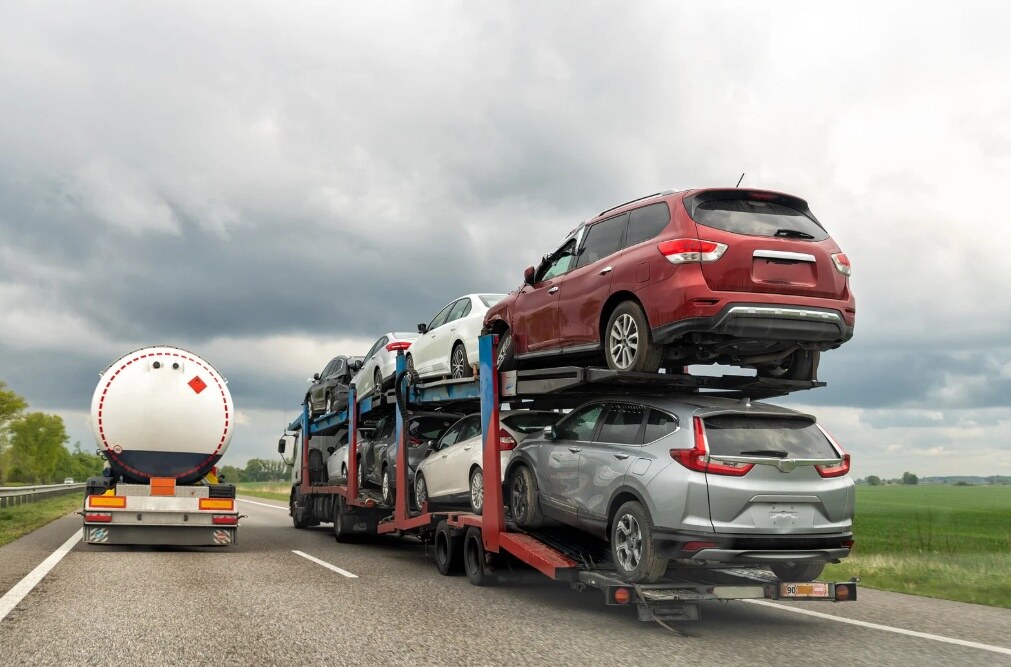 Pracownik portowy stojący na tle kontenerowców, symbolizujący transport i logistykę morską.